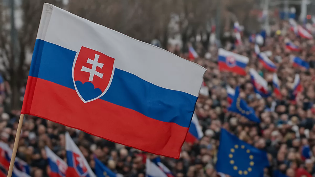 Demonštrácia v centre Bratislavy s davom ľudí držiacich transparenty a slovenské vlajky