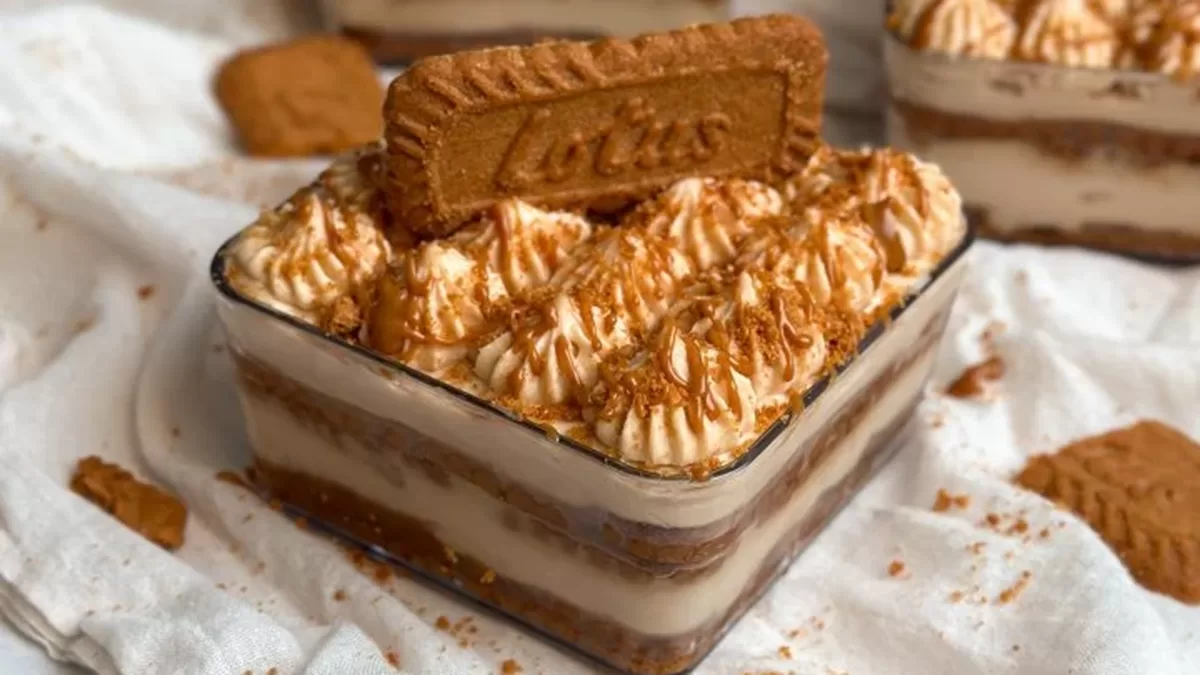 Sklenený pohár naplnený vrstveným Biscoff tiramisu s mascarpone krémom, karamelovou nátierkou a ozdobou z Biscoff sušienky navrchu.