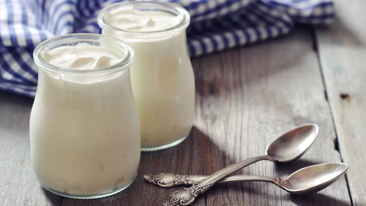 Biely jogurt v sklenenych poharoch na drevenom stole